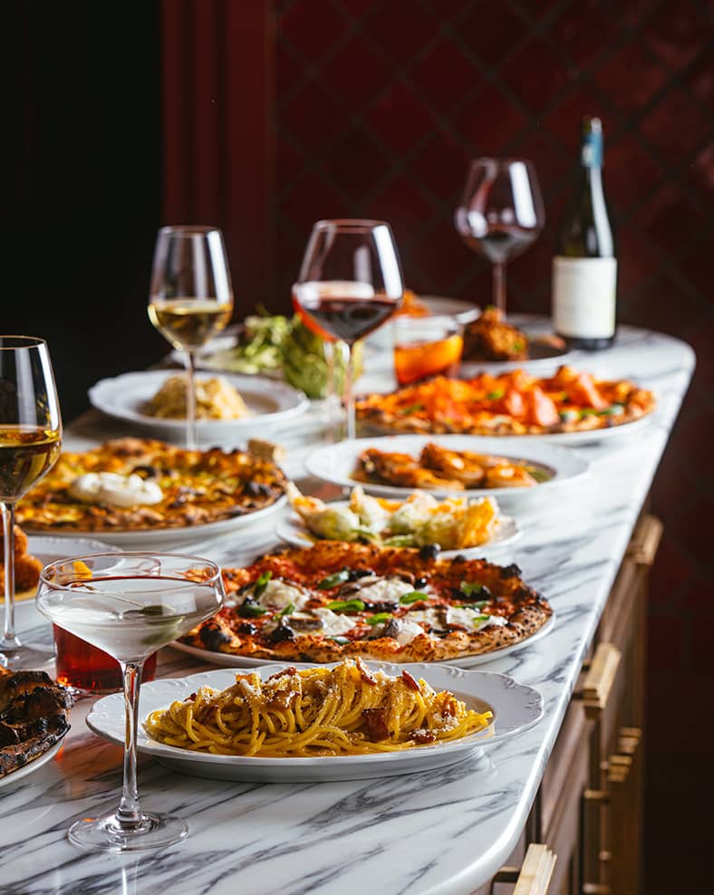 A table with multiple kinds of Italian dishes.