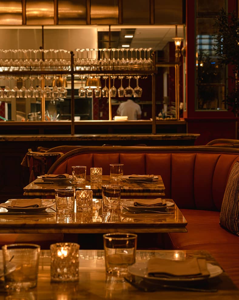 Mother Wolf interior, showing some tables in the front with a bar in the background.