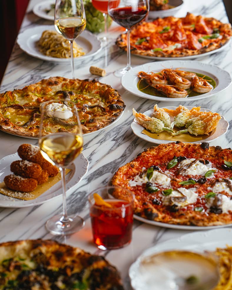 A table with multiple kinds of Italian dishes.