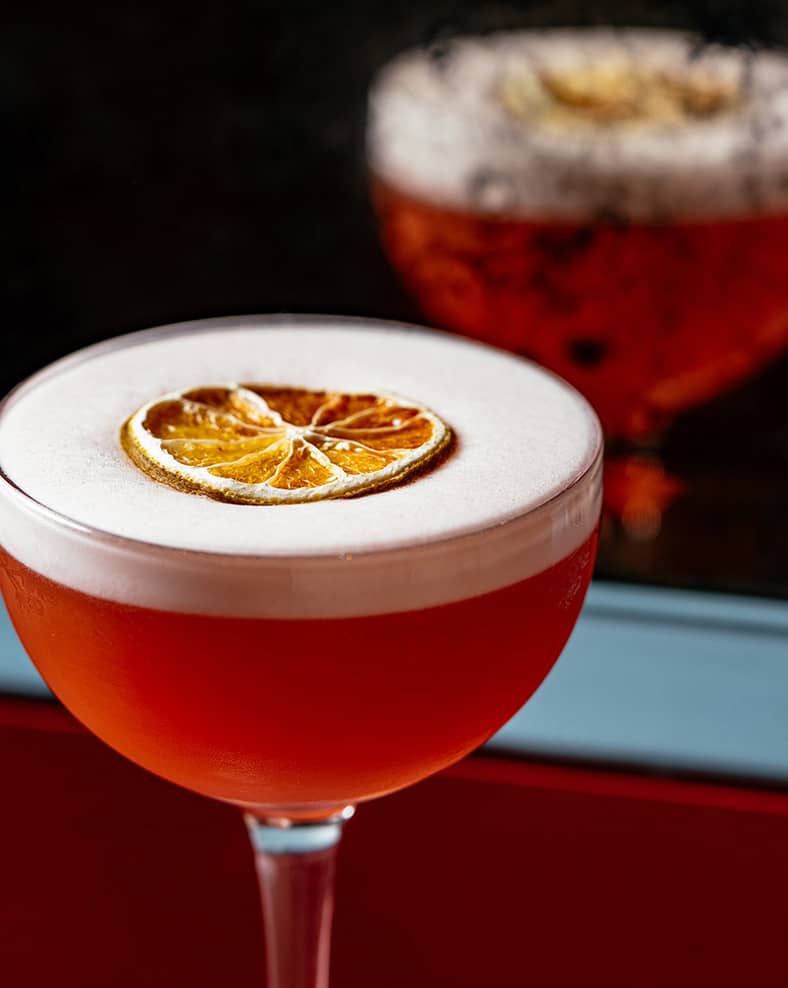 A cocktail with an orange slice